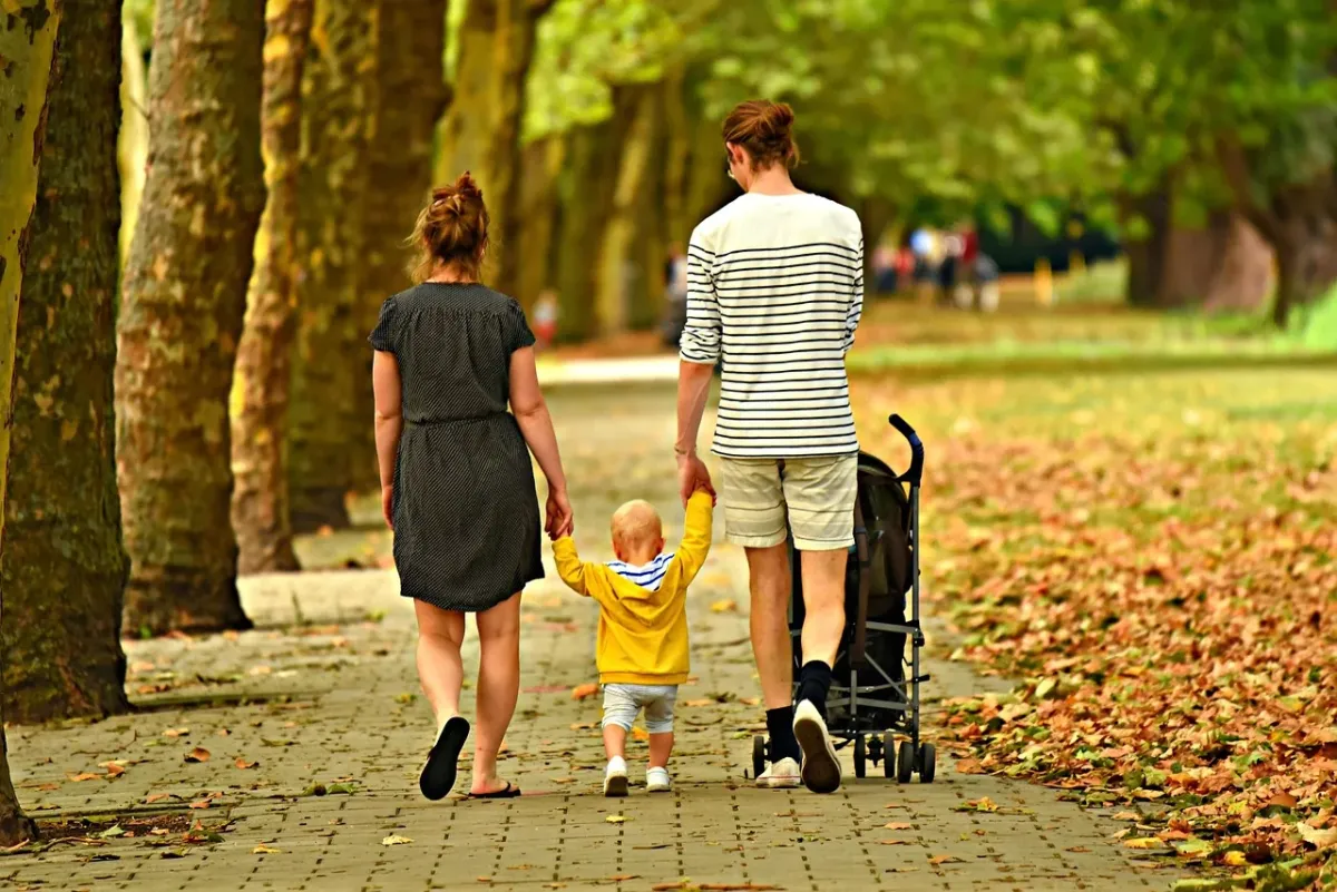 Ojciec czule obejmujący dziecko podczas wspólnego spaceru na świeżym powietrzu, podkreślający więź i rodzinną miłość.
